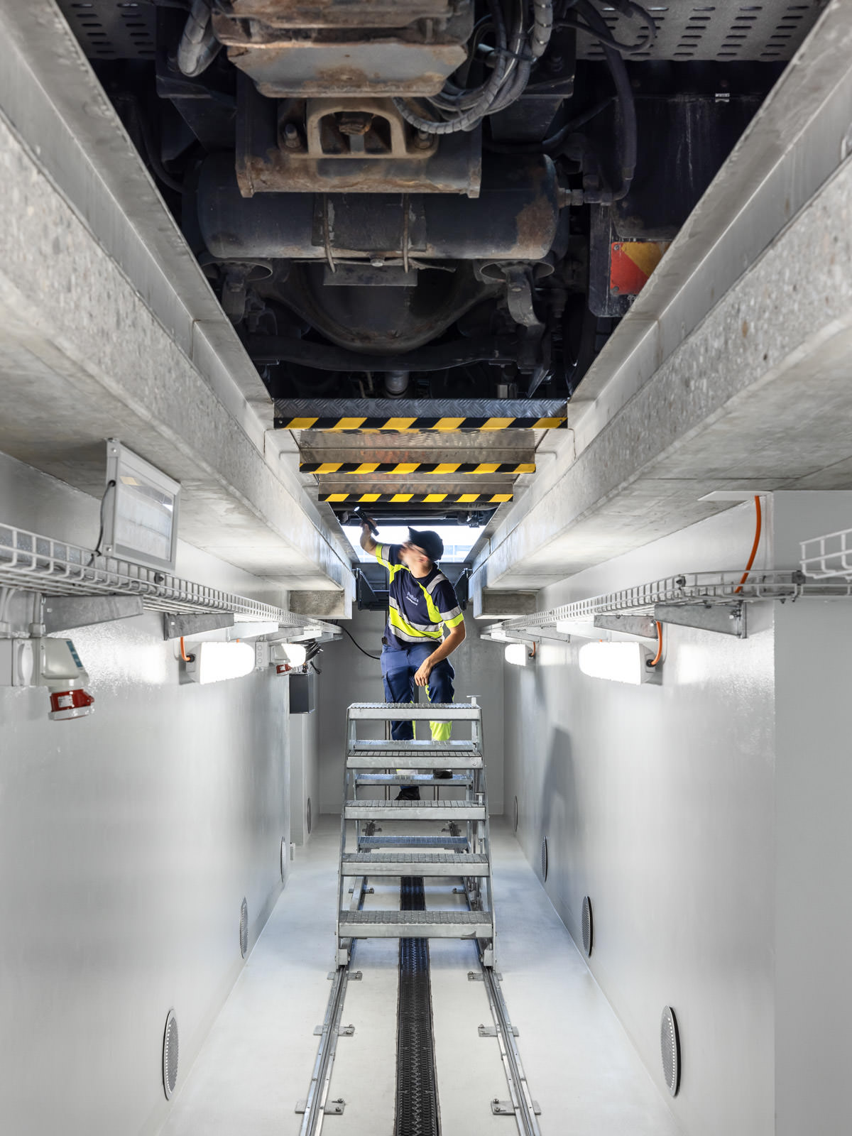 Garage pit, heavy truck inspection. Corporate technology photographer.